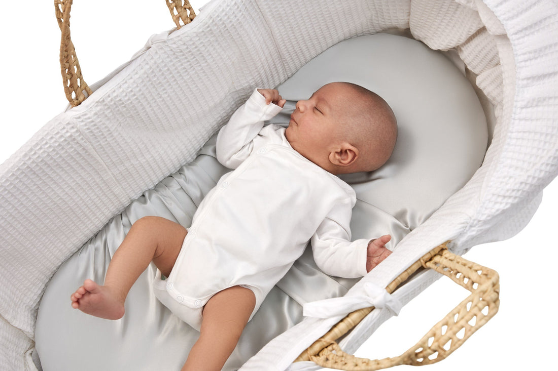 adorable newborn laying on a beddybyes silver grey Silk Moses Basket & Carrycot Fitted Sheet