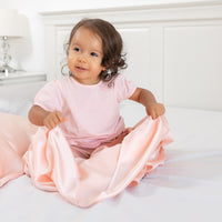 cute toddler girl holding a beddybyes blush pink Silk sheet